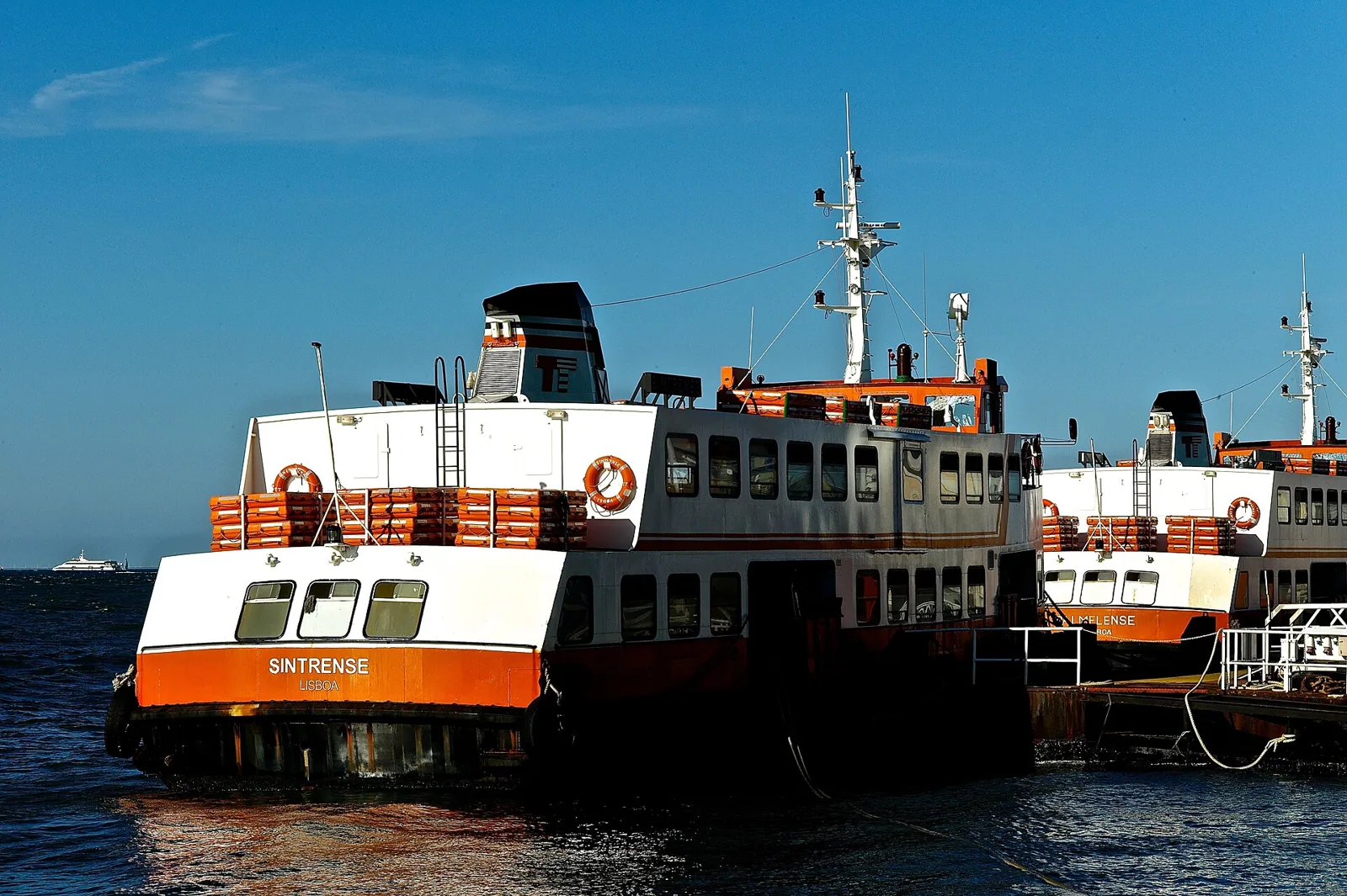 Traditional orange ferry boats connecting Cacilhas and Lisbon